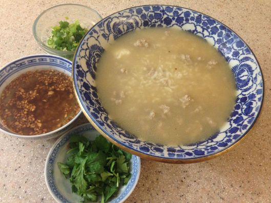 Thailand's rice porridge, kao tome, with chopped green onions, chopped cilantro, and crispy garlic in oil